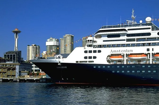 A large cruise ship moored on the Seattle waterfront with the Space Needle behind
